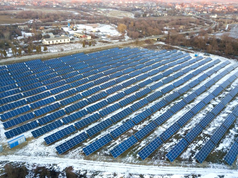 Blue solar photo voltaic panels system producing renewable clean energy in rural area in winter.